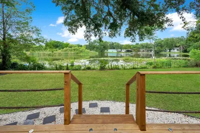 a wooden bench in front of a park with a lake at Lake view that is 10mins to Downtown and Parks for 2 Guests in Orlando