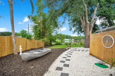 a backyard with a fence and a boat on the ground at Lake view that is 10mins to Downtown and Parks for 2 Guests in Orlando
