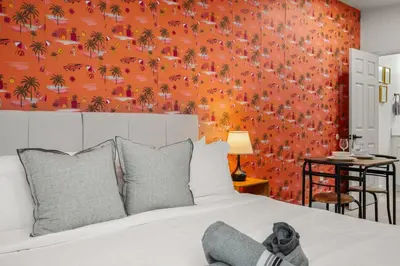 a bedroom with a bed with a orange wall at Charming Private Studio Near Everything Orlando in Orlando