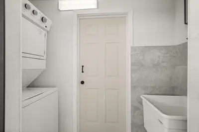 a white bathroom with a sink and a white door at Charming Private Studio Near Everything Orlando in Orlando