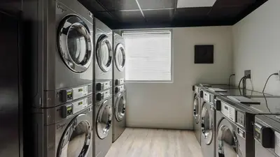 a laundry room with a bunch of washing machines at Apto 2Q no Meliá Celebration | Perto da Disney in Orlando