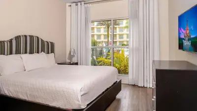a bedroom with a bed and a large window at Apto 2Q no Meliá Celebration | Perto da Disney in Orlando
