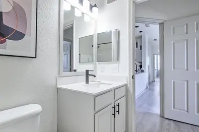 a white bathroom with a sink and a mirror at Landing Stunning 2BD Yoga Studio Gym in Kissimmee