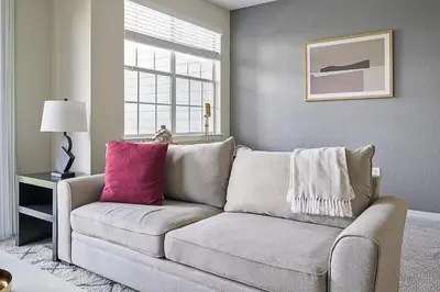 a living room with a couch and a window at Landing Stunning 2BD Yoga Studio Gym in Kissimmee