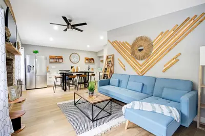 a living room with a blue couch and a table at Fireplace and Lake View Just 10 Minutes to Downtown Near Parks in Orlando