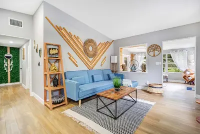 a living room with a blue couch and a table at Fireplace and Lake View Just 10 Minutes to Downtown Near Parks in Orlando