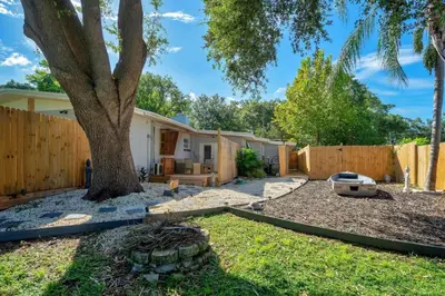 a house with a fence and a tree at Peaceful Lake View Retreat Near Parks 10 Minutes to Downtown in Orlando