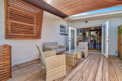 a patio with wicker chairs and a table on a deck at Peaceful Lake View Retreat Near Parks 10 Minutes to Downtown in Orlando