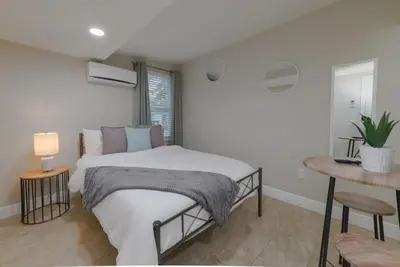 a white bedroom with a bed and a table at Comfy studio in Central Orlando in Orlando