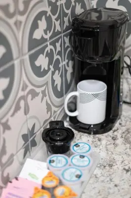 a counter with a coffee maker and a coffee mug and donuts at Comfy studio in Central Orlando in Orlando
