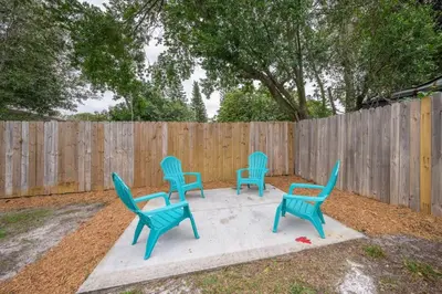 four blue chairs sitting on a concrete slab in front of a fence at Cozy 2 bedroom home in Orlando in Orlando