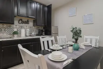 a kitchen with a dining table with white chairs and a tableablish at Cozy 2 bedroom home in Orlando in Orlando