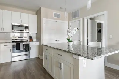a kitchen with white cabinets and a counter with flowers on it at Landing Incredible 1BD Clubhouse Gym in Orlando