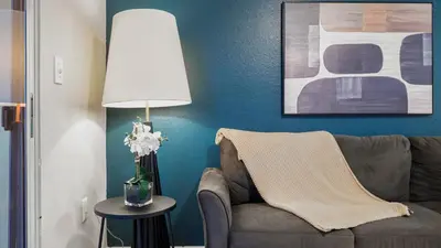 a living room with a couch and a table with a lamp at Landing Chic 1BD Gym in Orlando