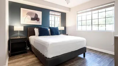 a bedroom with a large bed with blue walls at Landing Chic 1BD Gym in Orlando