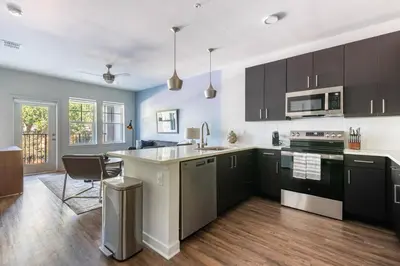 a kitchen with black and white cabinets and a table at Landing Beautiful 2BD in Kissimmee in Kissimmee