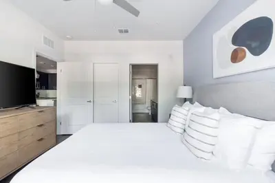 a white bedroom with a large bed with white pillows at Landing Beautiful 2BD in Kissimmee in Kissimmee