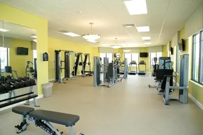 a gym with rows of treadmills and machines at 4715 SH - Storey Lake Hideaway 6BR Mansion Private Pool in Kissimmee