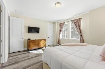 a white bedroom with a bed and a tv at Encore Resort luxury house 8 bedrooms, pool and spa in Orlando