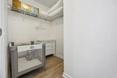 a walk in closet with a dresser and a crib at Arcade and Pool Villa, 4 km to Disney in Orlando