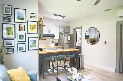 a kitchen and living room with a counter and stools at Salos Retreat, beautiful and peaceful stay in Saint Cloud