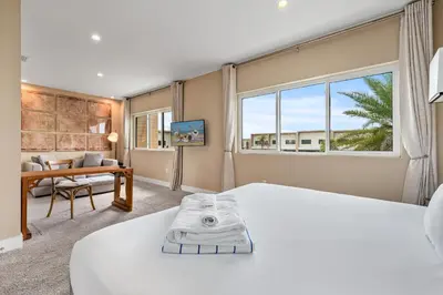 a bedroom with a large white bed and a desk at Bright and Modern Townhome at Magic Village – Superb Disney Location in Orlando
