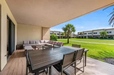 an outdoor patio with a wooden table and chairs at Bright and Modern Townhome at Magic Village – Superb Disney Location in Orlando