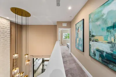 a dining room with a table and paintings on the walls at Bright and Modern Townhome at Magic Village – Superb Disney Location in Orlando