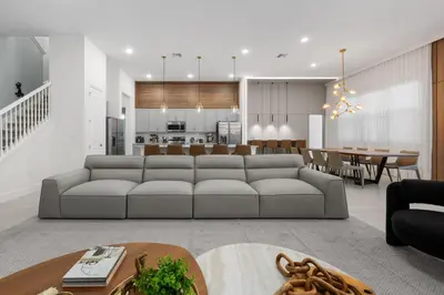 a living room with a couch and a dining room at Brand New Modern State of the Art Home! Sleeps 31 in Kissimmee