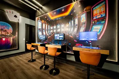 a pinball game room with orange chairs and consoles at Brand New Modern State of the Art Home! Sleeps 31 in Kissimmee
