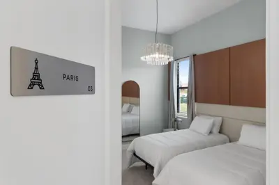 a bedroom with two beds and a chandelier at Brand New Modern State of the Art Home! Sleeps 31 in Kissimmee
