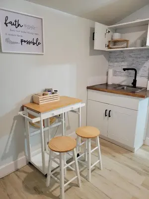 a small kitchen with a table and two stools at A cozy stay with everything you need! in Kissimmee