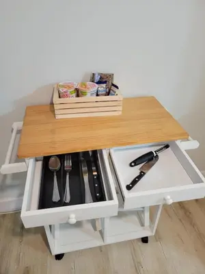 a table with a wooden top on a cart with utensils at A cozy stay with everything you need! in Kissimmee
