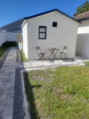 a patio with two chairs and a table in front of a building at A cozy stay with everything you need! in Kissimmee