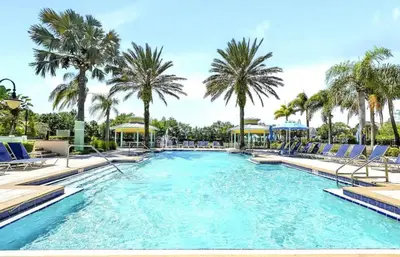 a swimming pool with chairs and palm trees at Magical Apartment DisneyFree ShuttleFree parking in Kissimmee