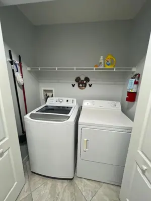 a kitchen with a stove and a washer and dryer at Magical Apartment DisneyFree ShuttleFree parking in Kissimmee