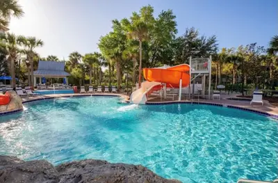a swimming pool with a slide in a resort at Magical Apartment DisneyFree ShuttleFree parking in Kissimmee