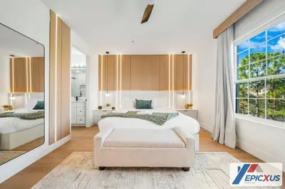 a bedroom with a bed and a chair and a window at The Epic 3 Lake View Vista Cay Resort Orlando Florida in Orlando