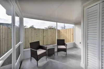 two chairs and a table on a balcony with windows at Pet Friendly Studio Unit Near Downtown and Parks - 20 mi to Disney in Saint Cloud