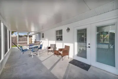a porch with a table and chairs and a dining room at Downtown Home with Basketball, Firepit and Just 20 Miles to Disney in Saint Cloud