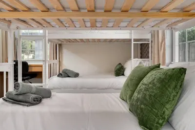 a bedroom with two white beds with green pillows at 10 Minutes to Downtown with Jacuzzi, Pool Table, Ping Pong, and BBQ in Orlando