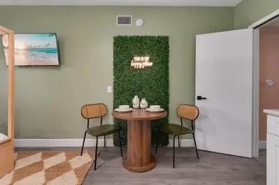 a table and chairs in a room with a green wall at Cozy Orlando Studio with Jacuzzi, Fire Pit, and BBQ in Orlando