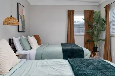 a living room with two beds and a couch at Stylish 2BR Home Near Disney and Universal Orlando in Orlando