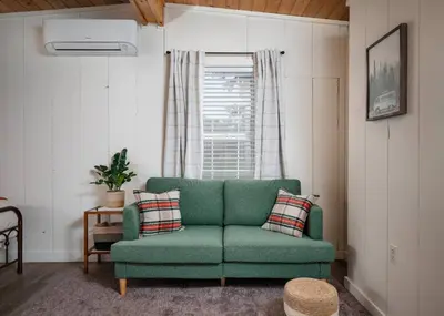 a green couch in a living room with a window at Modern Downtown Orlando Studio in a Prime Location in Orlando