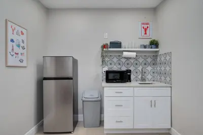 a kitchen with a stainless steel refrigerator and white cabinets at Hip Orlando Studio Nearby Restaurants and Parks in Orlando