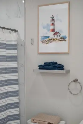 a bathroom with a picture of a lighthouse on the wall at Hip Orlando Studio Nearby Restaurants and Parks in Orlando