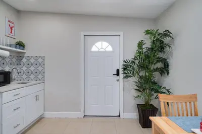 a white door in a kitchen with a plant at Hip Orlando Studio Nearby Restaurants and Parks in Orlando