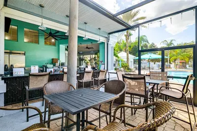 a patio with tables and chairs and a pool at Resort Perks! Family Home 4 Mi to Disney World in Kissimmee