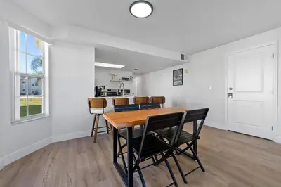 a dining room with a wooden table and chairs at Bright Ground Floor Condo Minutes to Parks in Kissimmee