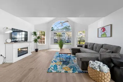 a living room with a couch and a fireplace at Bright Ground Floor Condo Minutes to Parks in Kissimmee